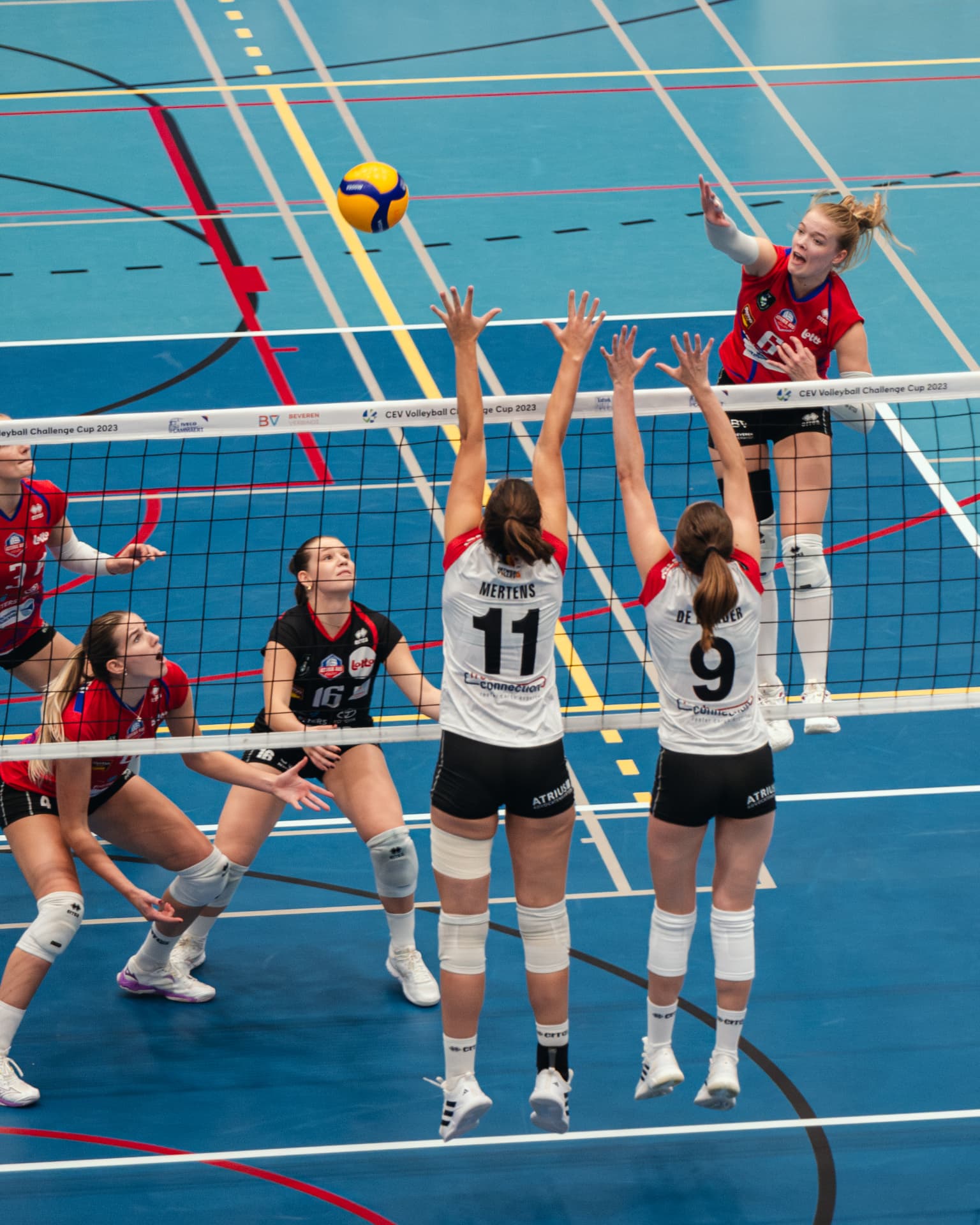 Attacker spiking over a double block at a CEV Challenge Cup match